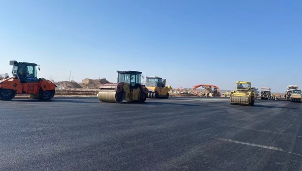 近日，在西部市政建設集團蘭州新區(qū)城市礦產與表面處理產業(yè)園區(qū)（二期）周邊基礎設施項目—園區(qū)西路南延段（緯五十路至緯二十八路）項目現(xiàn)場，隨著一輛輛運料車平穩(wěn)駛入，攤鋪機將滾燙的瀝青混合料均勻鋪開，標志著項